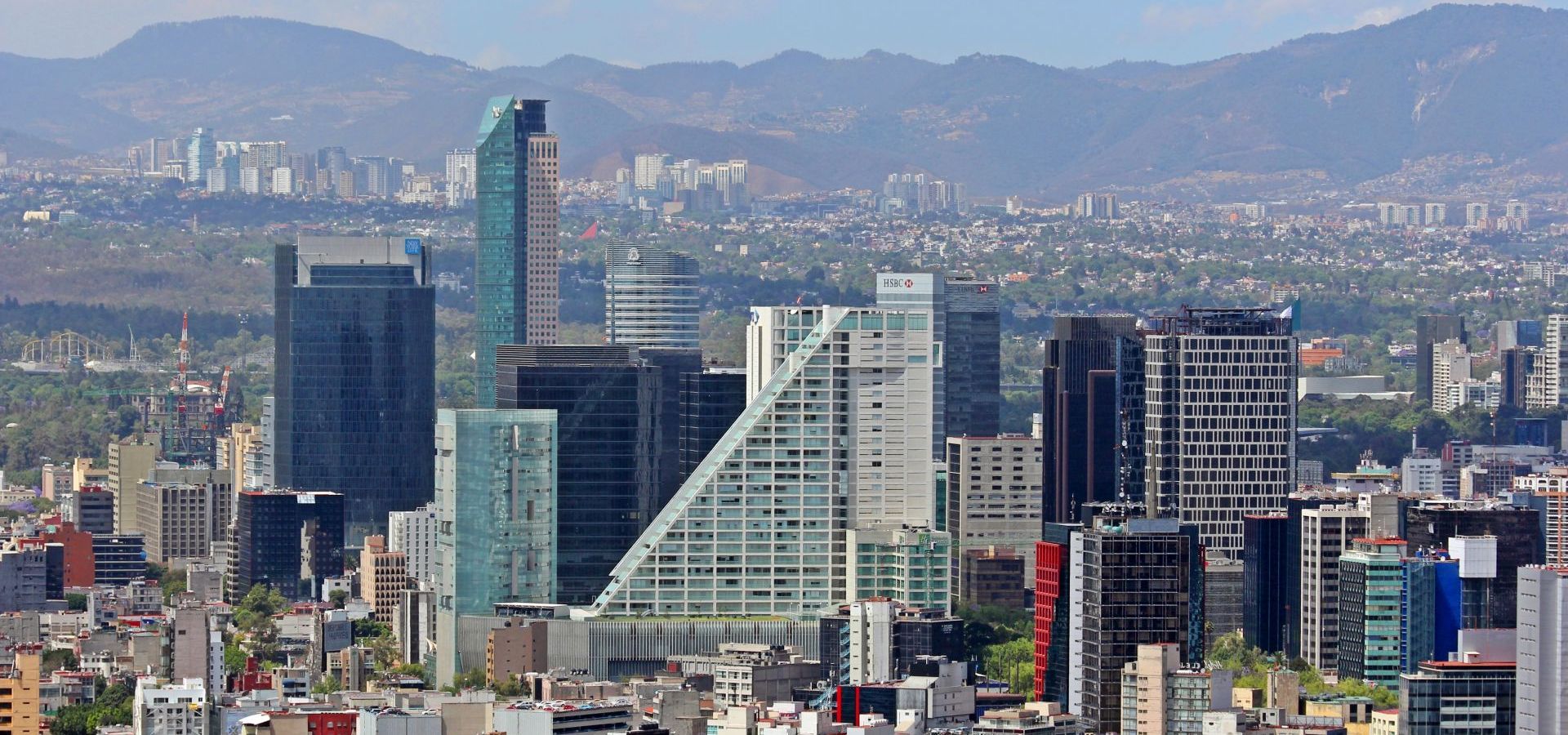 Skyscratchers of Mexico City with mountains in the background. 